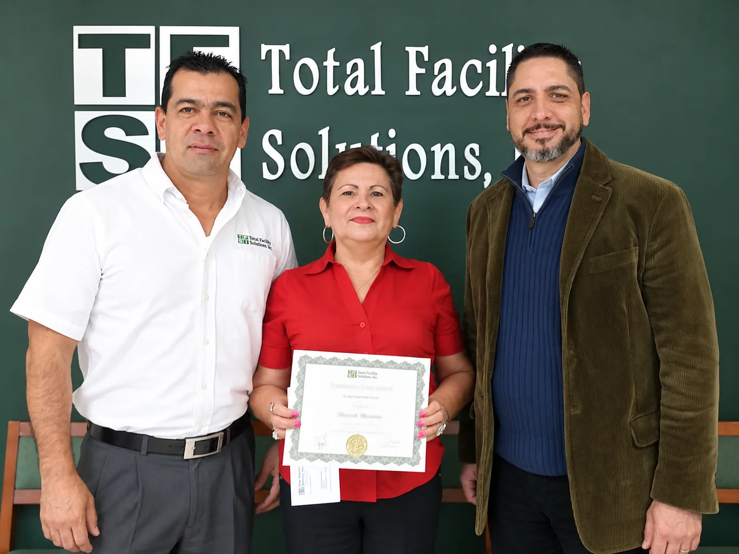 Past TFS employee recognition presentation showing recipients with a certificate